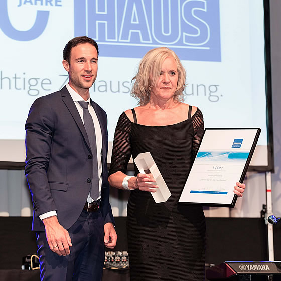 Philipp Roth, Mitglied des Vorstandes des BAUMEISTER-HAUS Kooperation e.V. überreicht Roswitha Hilpert von Projektbau Mutter für ihre Idee „Dankes-Karten“ den BAUMEISTER-HAUS Innovationspreis 2017.