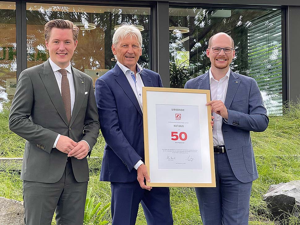 Christian Huf (l.) und Benedikt Huf (r.) erhielten die Jubiläumsurkunde von BDF-Präsident Hans Volker Noller (m.). Foto: HUF HAUS