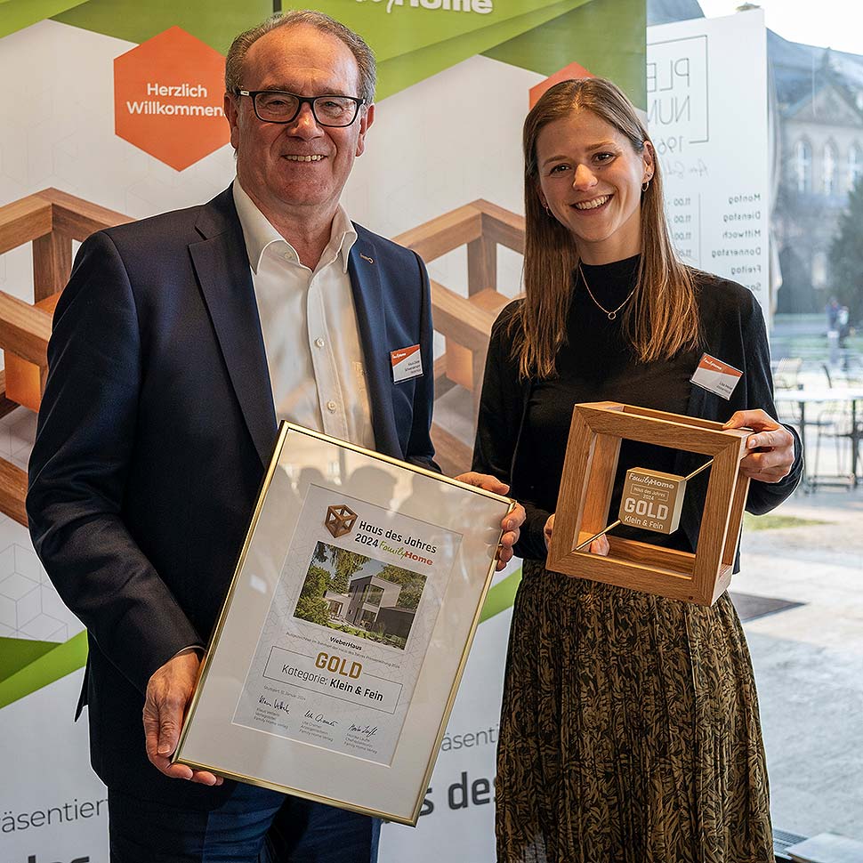 Bei der Preisverleihung zum „Haus des Jahres 2024“ nahmen Klaus-Dieter Schwendemann, Marketingleiter bei WeberHaus, und Lisa Meier, Pressereferentin bei WeberHaus, die Gold-Auszeichnung in der Kategorie „Klein & fein“ entgegen. Foto: WeberHaus