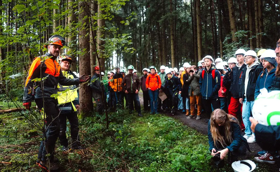 Schüler der 9. Jahrgangsstufe des Gymnasiums Eggenfelden auf dem Waldlehrpfad der WBV Eggenfelden-Arnstorf in Mertsee, Gemeinde Falkenberg bei der praktischen Demonstration einer Baumfällung durch Markus Fechter Foto: Holz rettet Klima / Buschendorf