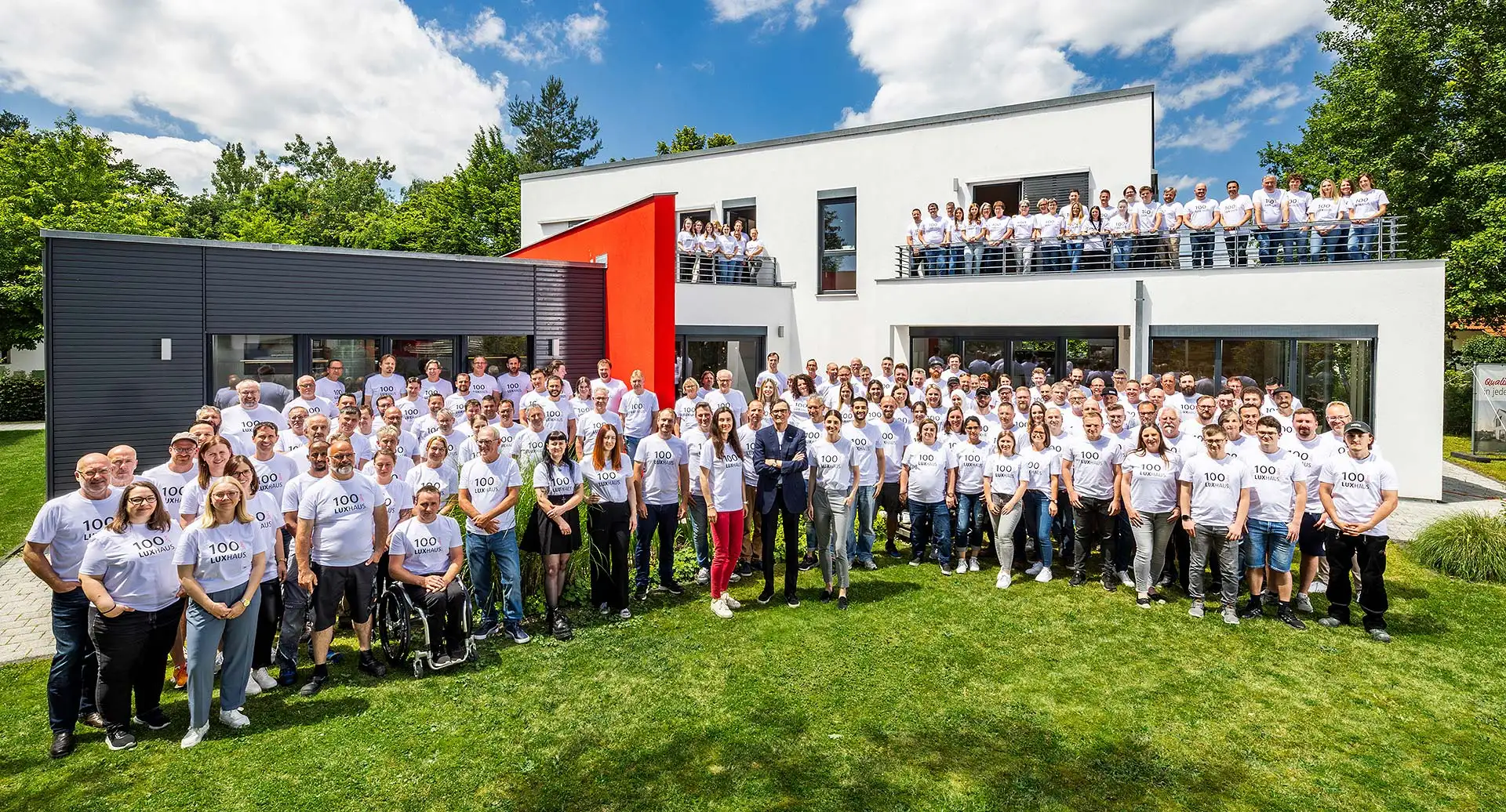 Gemeinsam stark: Die gesamte LUXHAUS-Belegschaft feiert 100 Jahre Unternehmensgeschichte vor unserem Musterhaus in Georgensgmünd. Alle Mitarbeiter tragen das Jubiläums-T-Shirt. Foto: Konturlicht Fotografie Volker Lau