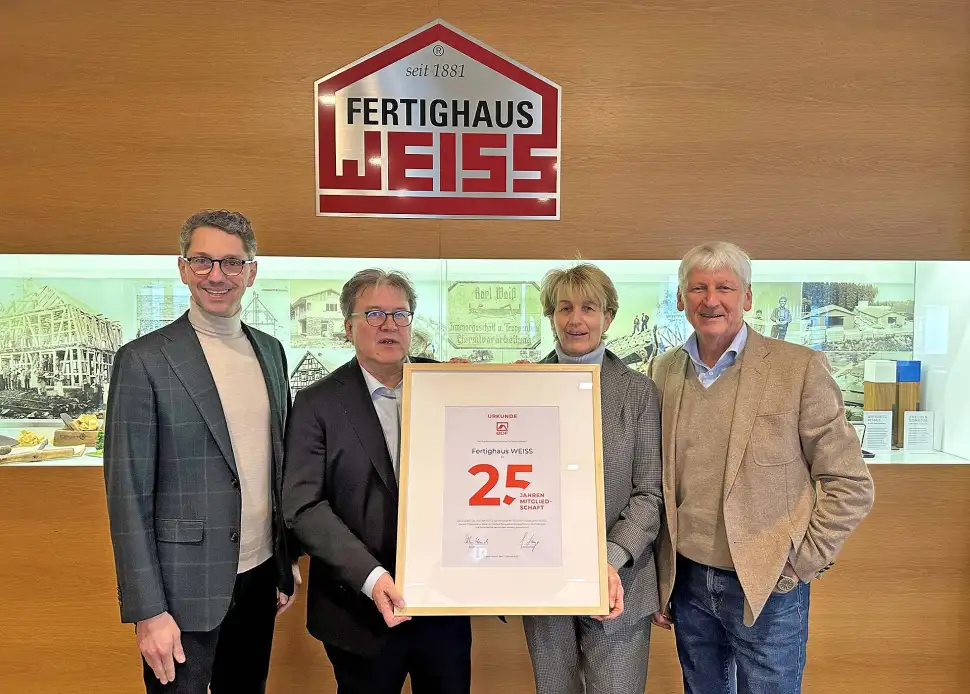 BDF-Geschäftsführer Achim Hannott (2.v.l.) überreichte die Jubiläumsurkunde an Christel Noller, Hans Volker Noller (r.) und Michael Noller (l.). Foto: BDF / Fertighaus WEISS