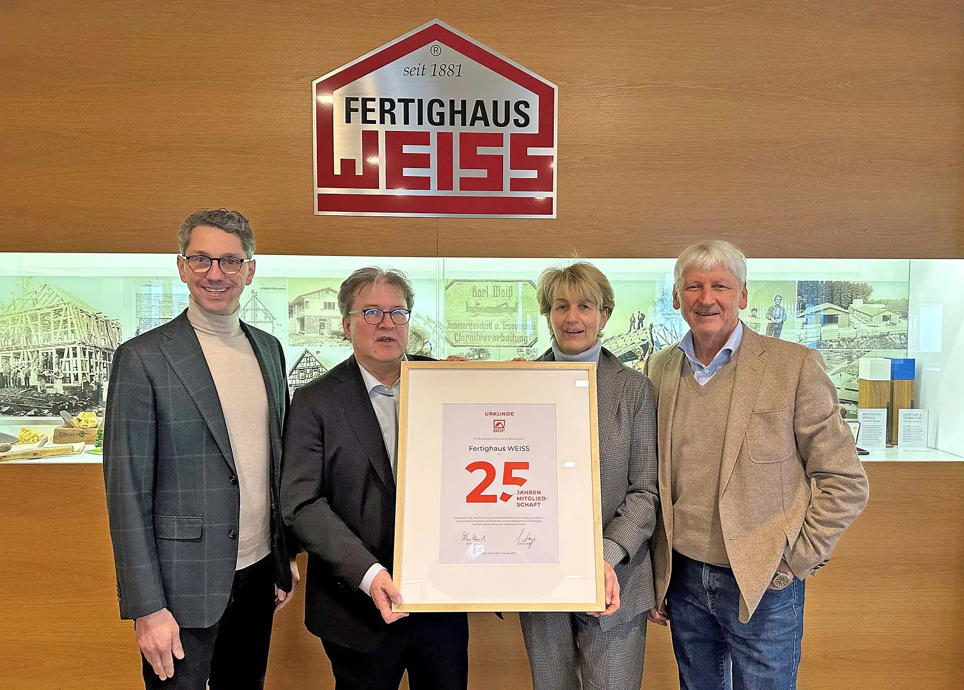 BDF-Geschäftsführer Achim Hannott (2.v.l.) überreichte die Jubiläumsurkunde an Christel Noller, Hans Volker Noller (r.) und Michael Noller (l.). Foto: BDF / Fertighaus WEISS