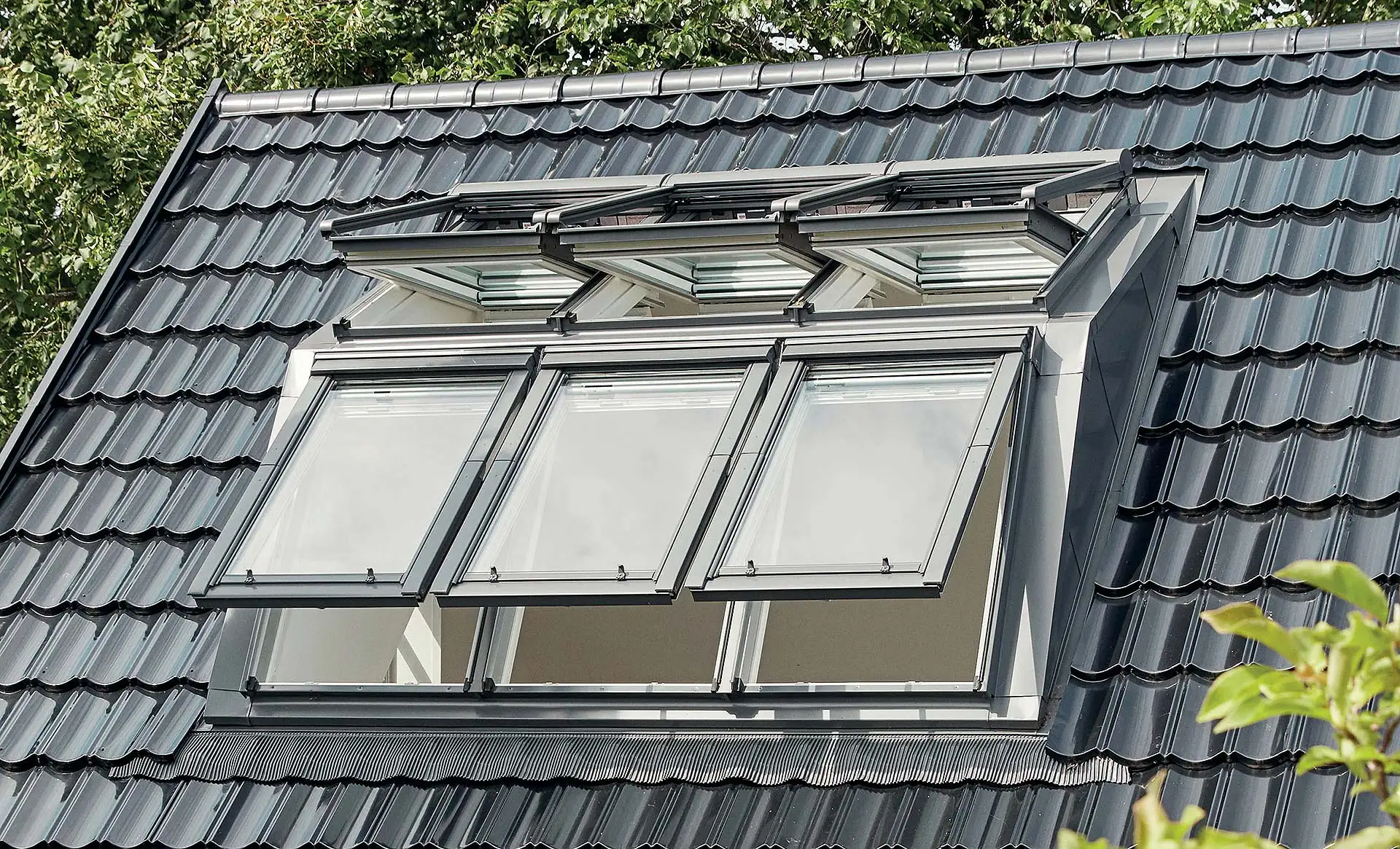 Wer die Vorteile von Dachfenstern und Gaube kombinieren will, kann diese Panorama-Lichtlösung nutzen. Mit ihr profitiert man von mehr Wohnfläche und maximaler Tageslicht-Ausbeute, da der obere Teil der gaubenähnlichen Konstruktion nicht mit einer Eindeckung, sondern mit Dachfenstern geschlossen wird. Foto: Velux / akz-o