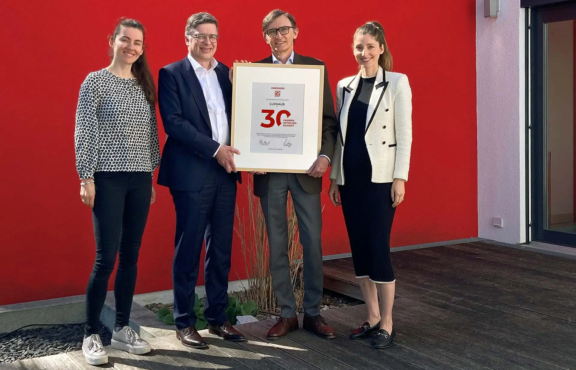 Julia Lux (l.), Maria Lux (r.) und Alexander Lux (2.v.r.) erhielten jetzt eine Jubiläumsurkunde für ihr Familienunternehmen LUXHAUS von BDF-Geschäftsführer Georg Lange (2.v.l.). Foto: BDF/LUXHAUS