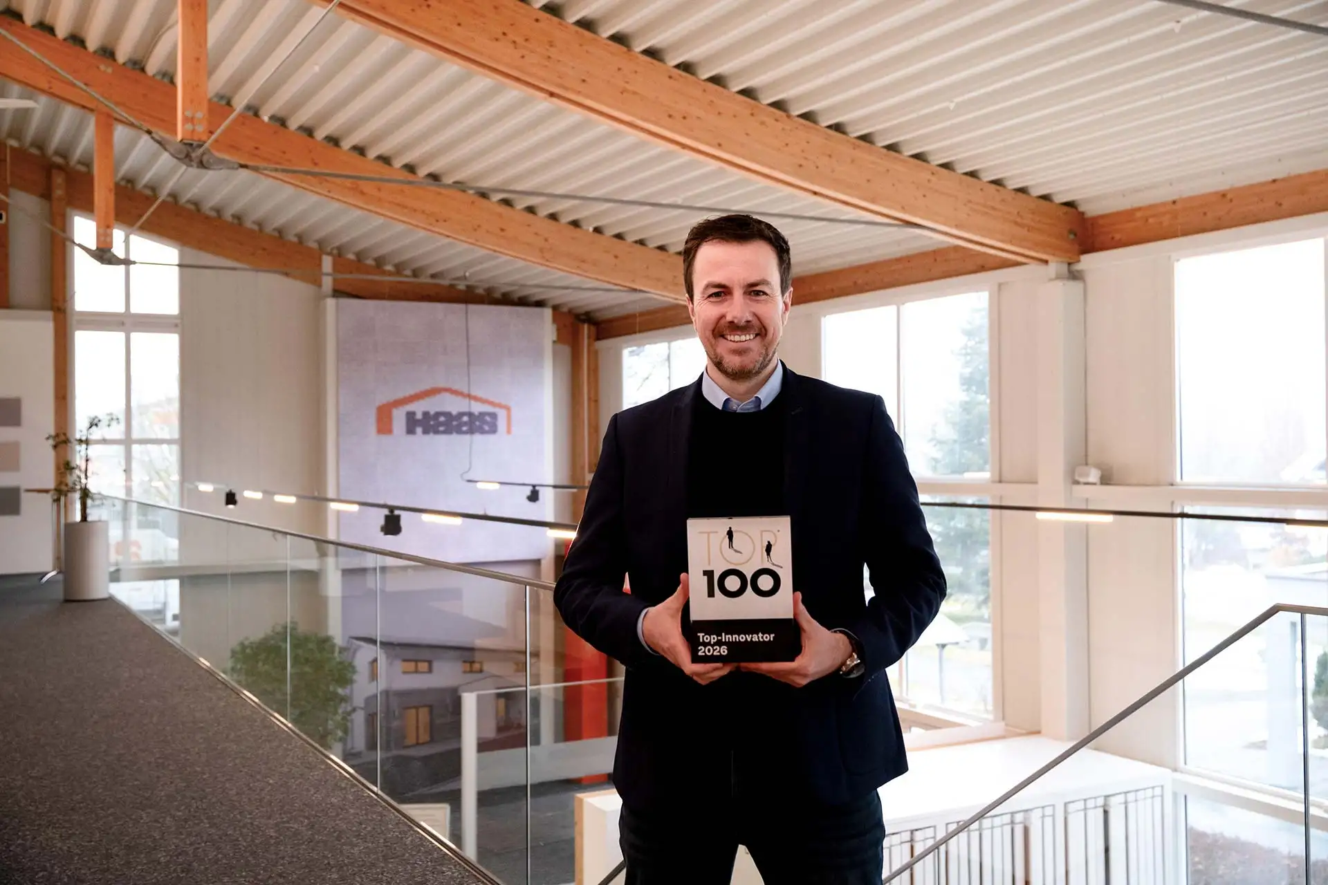 Xaver A. Haas, Gesch&auml;ftsf&uuml;hrenden Gesellschafter Haas Group, mit den TOP100 Siegel im Kundenforum in der Firmenzentrale in Falkenberg. Foto: Haas Fertigbau