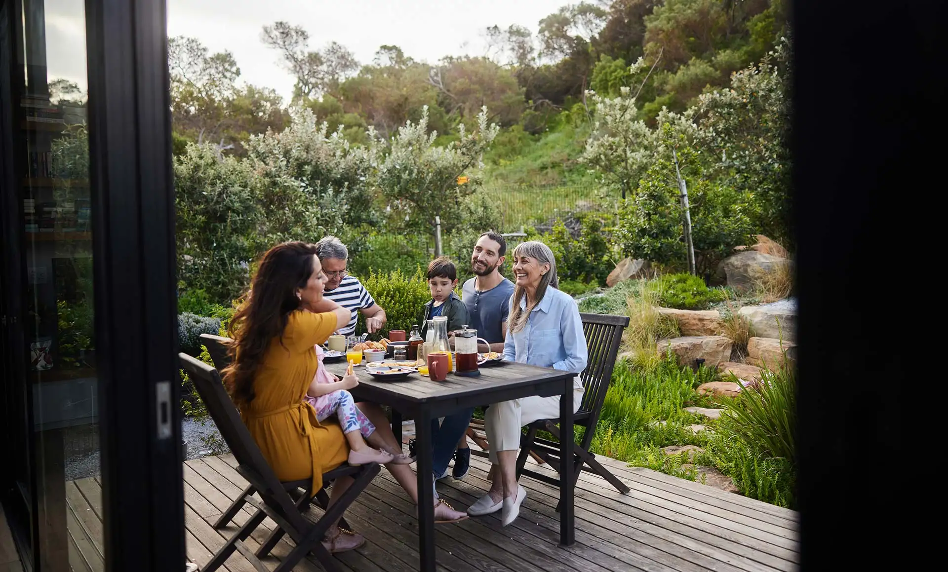 Sommerzeit ist Draußenzeit: Auf der Terrasse wird das Fertighaus zum Treffpunkt für Familie und Freunde – hier verlagert sich das Leben an warmen Tagen ganz selbstverständlich nach draußen. Foto: istockphoto.com / Goodboy Picture Company